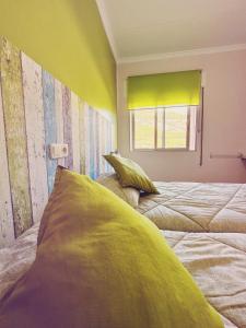 a bedroom with a bed with a yellow wall at Fonda Aparicio in Fuentespalda +31 photos