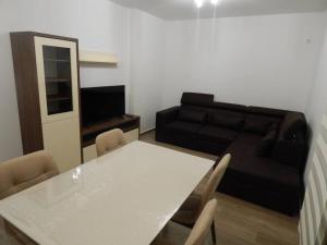 een woonkamer met een witte tafel en een zwarte bank bij Zvezda vodilja 2 in Veternik
