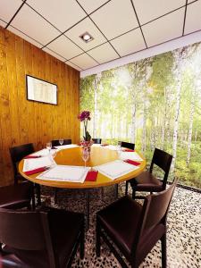 una sala da pranzo con tavolo, sedie e murale nel bosco di Fonda Aparicio a Fuentespalda