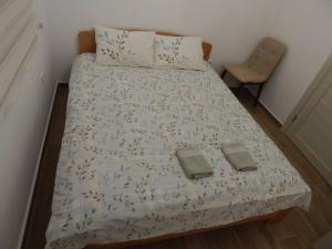 een bed in een slaapkamer met 2 handdoeken erop bij Zvezda vodilja 2 in Veternik