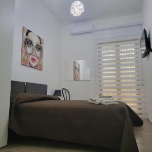 a bedroom with a bed and a picture of a woman at B&B DEI SOGNI in centro, con facilità di parcheggio in Cosenza