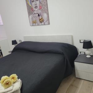 a bedroom with a black bed with a picture on the wall at B&B DEI SOGNI in centro, con facilità di parcheggio in Cosenza