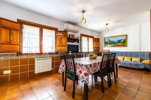 uma cozinha com uma mesa e cadeiras e um sofá em Casa Rural Las Huertas de Roque em Monachil