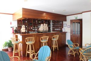 a bar with chairs and a counter with wine bottles at Hotel Santo Antonio Da Baia in São Martinho do Porto