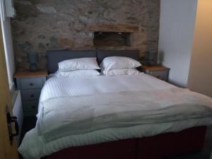 una camera da letto con un grande letto con due comodini di NEWFIELD INN a Broughton-in-Furness