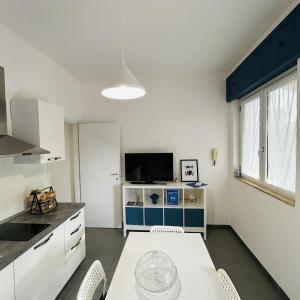 cocina con mesa y TV en una habitación en La casa del nonno - Villapiana, en Villapiana