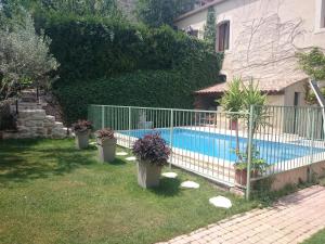 a fence around a swimming pool in a yard at Les Fontaines du Mas des Fontaines in Montagnac +43 photos