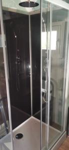 a shower with a glass enclosure in a bathroom at Jolie péniche canal du Midi in Vias