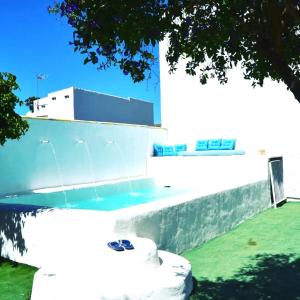 um edifício branco com uma fonte em frente em Villa Buganvillas, relax con piscina privada a pocos minutos de la Barrosa y Santi Petri em Chiclana de la Frontera