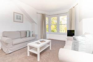 a white living room with a couch and a table at Park View Place Buxton in Buxton