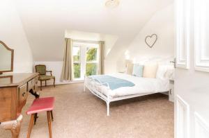 a white bedroom with a bed and a desk at Park View Place Buxton in Buxton