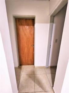 an empty hallway with a wooden door in a room at Departamento Viajeros Ruta 6 in General Roca