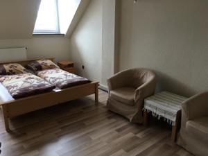 ダルウォボにあるPokoje Gościnne na Podzamczuのベッドルーム1室(ベッド1台、椅子、窓付)