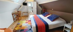 a bedroom with a bed with colorful blankets and pillows at Le Relais des 4 Saisons - Chambres d'hôtes B&B en Baie de Somme in Saint-Valéry-sur-Somme