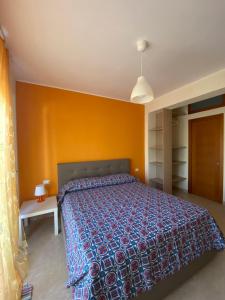 1 dormitorio con cama y pared amarilla en Villanna, en Sperlonga