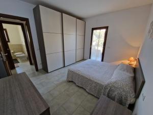 1 dormitorio con 1 cama y baño en Da Sale en Budoni