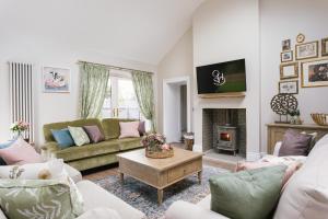 a living room with a couch and a fireplace at The Farmhouse at Corrstown Village in Portrush