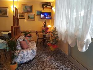 - un salon avec une fille assise sur un canapé dans l'établissement Hotel Villa Ersilia Rimini B&B, à Rimini