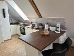 a kitchen with a counter with two chairs in it at Appartement Bali in Hüllhorst