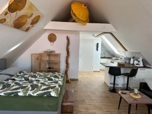 a bedroom with a bed and a table and a kitchen at Appartement Bali in Hüllhorst