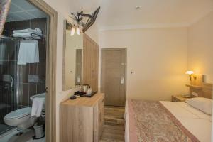 a hotel room with a bed and a bathroom at Arsi Enfi City Beach Hotel in Alanya