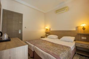 una habitación de hotel con una cama grande. en Arsi Enfi City Beach Hotel, en Alanya