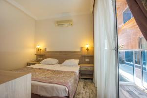 a hotel room with two beds and a balcony at Arsi Enfi City Beach Hotel in Alanya