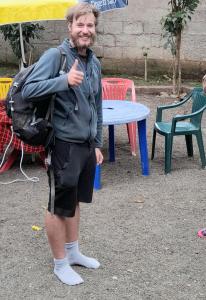 a man giving a thumbs up in front of a table at ArushaLand homestay in Arusha