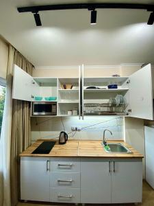 a kitchen with white cabinets and a sink at Room 27 in Kutaisi in Kutaisi