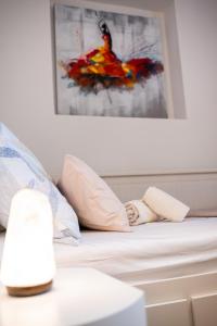 uma cama com almofadas e um quadro na parede em Luxury rooms Erceg em Zadar