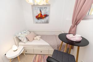 um pequeno quarto com uma cama e uma mesa em Luxury rooms Erceg em Zadar