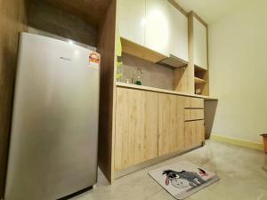 La cuisine est équipée d'un réfrigérateur en acier inoxydable et de placards en bois. dans l'établissement WinnieThePooh#BathtubPoolSeaview, à Malacca