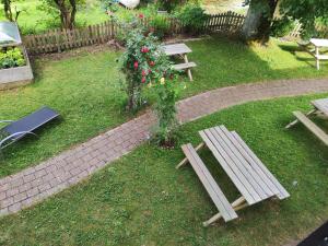 twee houten picknicktafels en een bos met rozen bij Landhaus Weißer Hirsch in Füssen