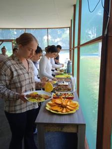 a group of people standing around a table with plates of food at Amazon Macambo Lodge in Iquitos +25 photos