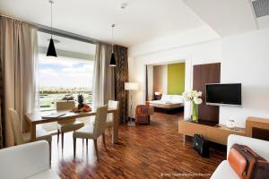 a living room with a table and a room with a bed at Eureka Palace Hotel Spa Resort in Cassibile
