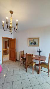 ein Esszimmer mit einem Tisch, Stühlen und einem Kronleuchter in der Unterkunft Casa Carmela Panoramic Center Apartment in Taormina