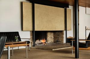 a living room with a fireplace and a couch at Energihotellet in Nesflaten