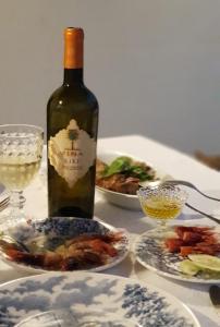 una botella de vino y platos de comida en una mesa en Jess & Joe's en Castelvetrano Selinunte