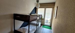a room with two bunk beds in a room at 400m de la mer, calme, lumineux, parking privatif, 3 chambres max 6 personnes in Koksijde