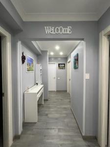 a bathroom with a welcome sign on the wall at The Queen Tropea in Tropea