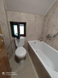 a bathroom with a toilet and a bath tub at Apartment Savkovic in Šipovo +38 photos