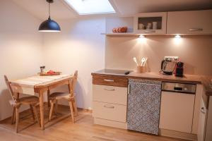 cocina con mesa, mesa pequeña, mesa y mesa en Erika´s Häuschen, en Kitzbühel