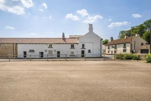 um grande edifício branco com uma rua em frente em The Old Bells em Doncaster