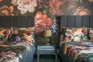 um quarto com duas camas e flores na parede em The Old Bells em Doncaster