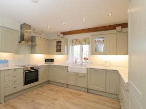 a kitchen with white cabinets and a sink at North Lodge in Malmesbury