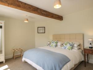 een slaapkamer met een groot bed met blauwe lakens en kussens bij North Lodge in Malmesbury