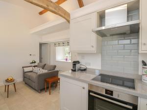 eine Küche und ein Wohnzimmer mit einem Sofa in der Unterkunft The Grooms Flat in Malmesbury