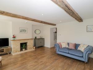 sala de estar con sofá azul y chimenea en The Cottage en Malmesbury