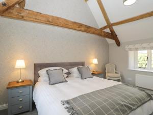 a bedroom with a large bed with two pillows at The Cottage in Malmesbury