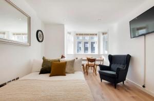 a bedroom with a bed and a chair and a table at Cozy 1 bedroom apartment in Notting Hill in London